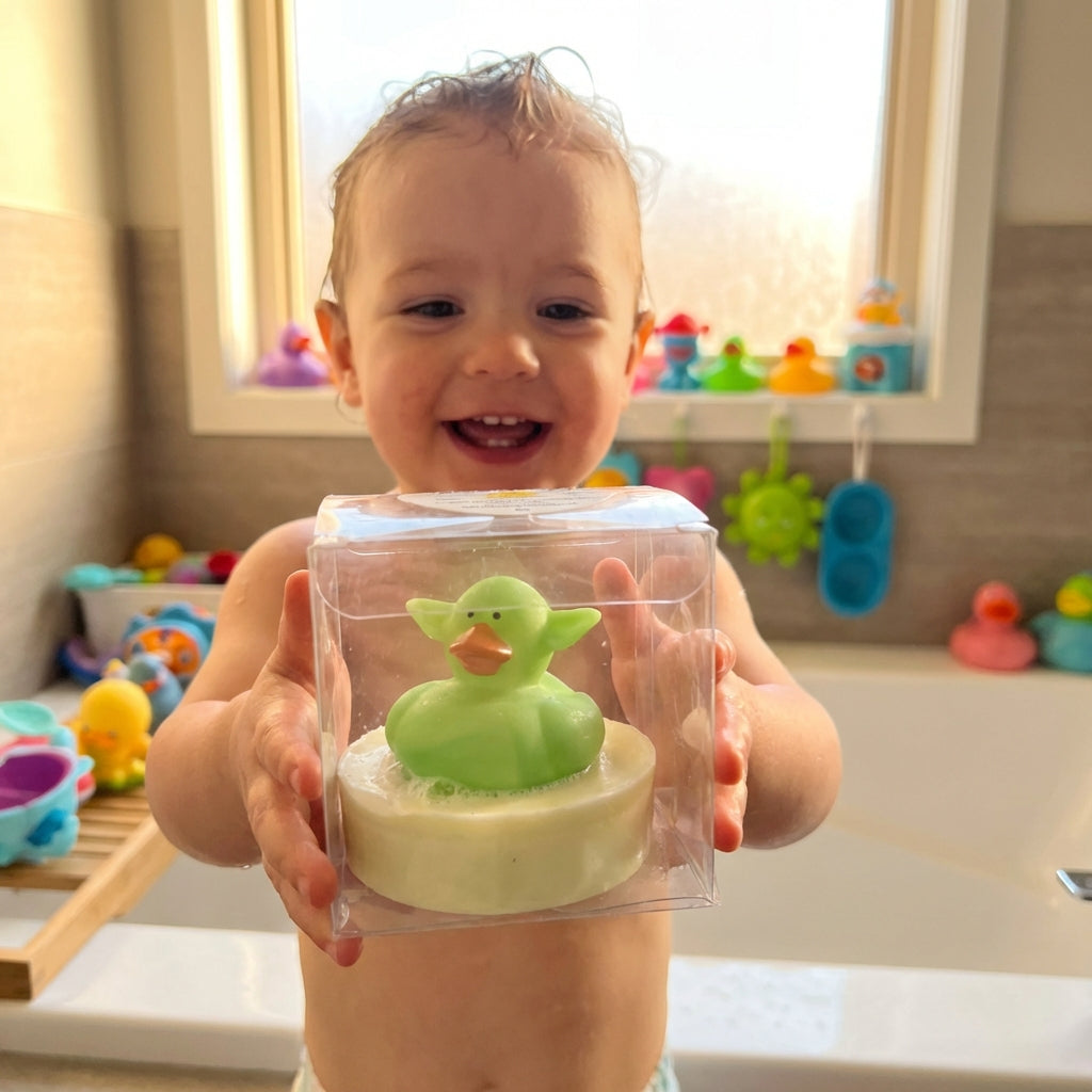 A lifestyle scene showing a happy child in a modern bathroom, holding a Little Buds Soap with the animal toy clearly visible. The camera is positioned at a child's eye level, using a wide-angle lens with a shallow depth of field to focus on the child's del
