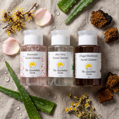 Overhead scene of facial cleanser surrounded by botanicals, water droplets, and linens on neutral cloth for calm ambiance.