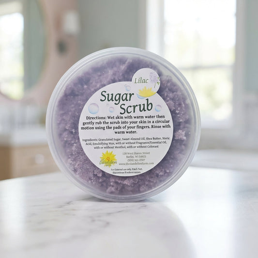 Capture a close-up, macro shot of the 'Sugar Scrub' jar on a sleek white marble surface, illuminated by softbox lighting to emphasize its creamy texture and luxurious branding. Use a shallow depth of field with a 100mm macro lens, showcasing the detailed g