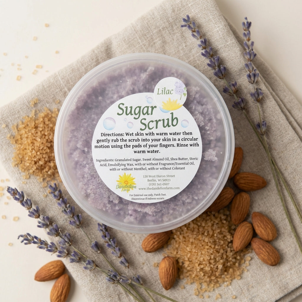 Illustrate a product-focused, flat-lay shot of the 'Sugar Scrub' jar surrounded by key ingredients like raw sugar, almond nuts, and a few sprigs of lavender on a textured linen cloth. The lighting is softbox and diffuse, highlighting textures and subtle sh