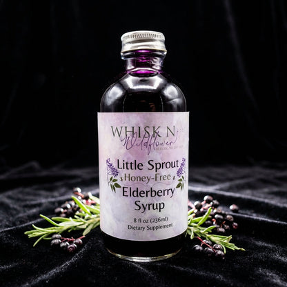 An elegant product shot featuring the Little Sprout Elderberry Syrup on a black velvet surface to create contrast, illuminated by rim lighting that accentuates the contours and glass transparency. The syrup's deep, vibrant purple color gleams against the d