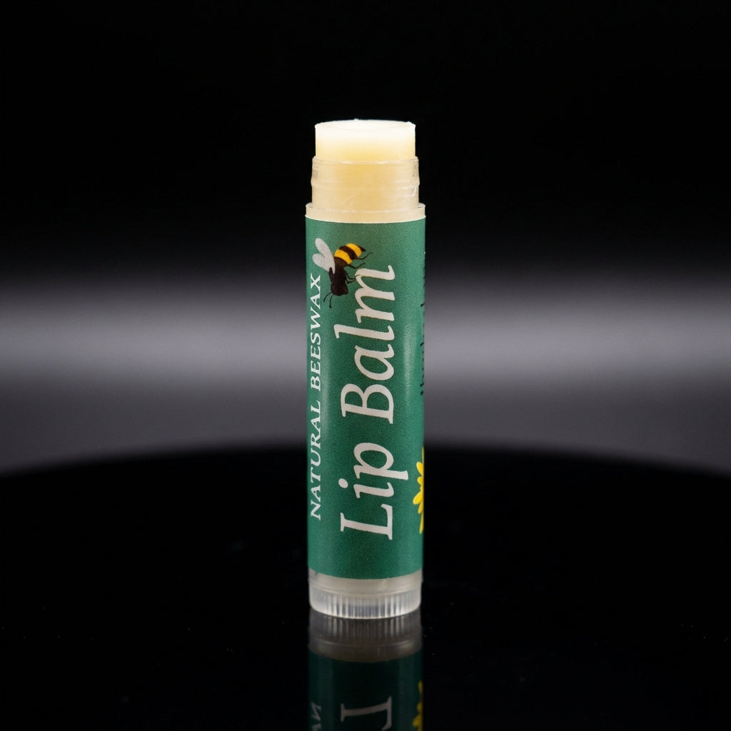 A studio product shot of the 'Natural Bees Wax Lip Balm' standing upright on a reflective black surface under sophisticated, softbox lighting. The camera, set with a macro lens at 100mm, captures minute details of the product’s embossed logo, the textured 