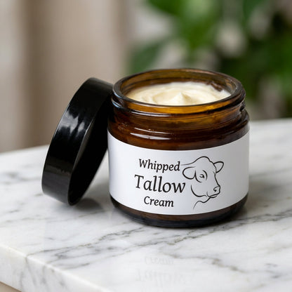Capture a close-up shot of the 'Whipped Tallow Cream' jar on a sleek white marble countertop, illuminated by softbox lighting to emphasize the creamy texture and subtle sheen of the whipped moisturizer. Use a macro lens (100mm) with a shallow depth of fiel
