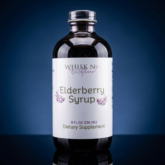 A highly detailed studio shot of a 2 oz elderberry syrup bottle, captured with a softbox lighting setup that accentuates the glass's clarity and the rich, viscous texture of the syrup inside. The bottle is positioned centrally on a reflective black surface