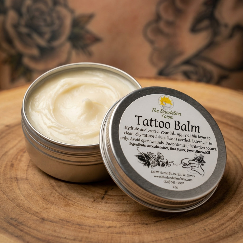A high-resolution studio shot of the Tattoo Balm, with a sleek glass jar open to reveal its rich, creamy texture. The scene is lit with softbox lighting, creating a smooth, diffused glow that highlights the luscious butter and oil ingredients on a natural 