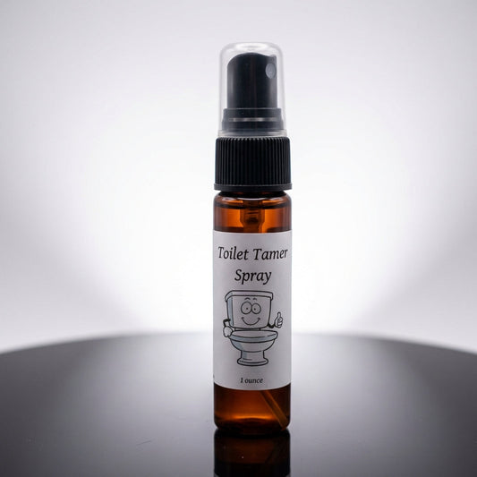 A high-resolution studio shot of the 'Toilet Tamer' spray bottle, positioned front and center on a sleek, reflective black surface that emphasizes its modern design. Softbox lighting creates a gentle, even glow that highlights the transparent glass of the 
