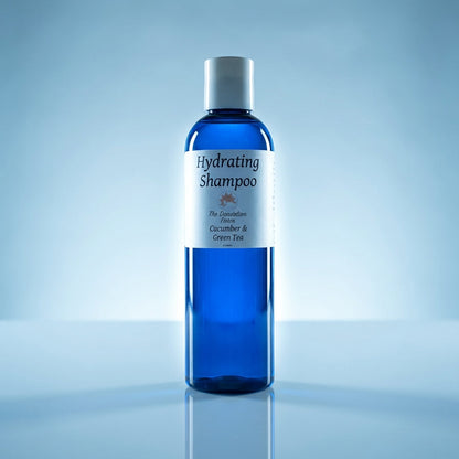 A cinematic, studio-grade shot of the shampoo bottle placed on a smooth, reflective surface with a soft, bluish tint background, suggesting freshness and hydration. Rim lighting from the sides creates a halo effect around the product, emphasizing its shape