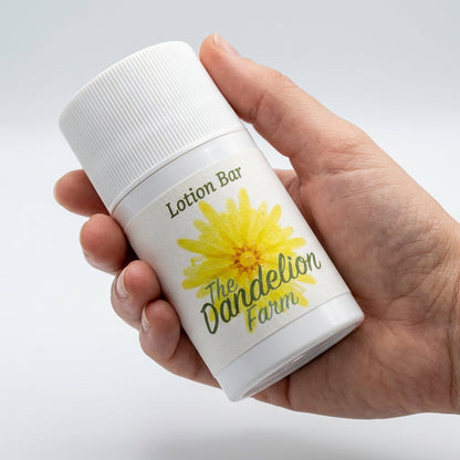 3. A dynamic product showcase on a bright, neutral-colored studio backdrop, lit with HDR studio lights for even, detailed illumination. The 'Lotion Bar' is held in a model’s hand, demonstrating its size and ease of use. The camera uses a macro lens set to 