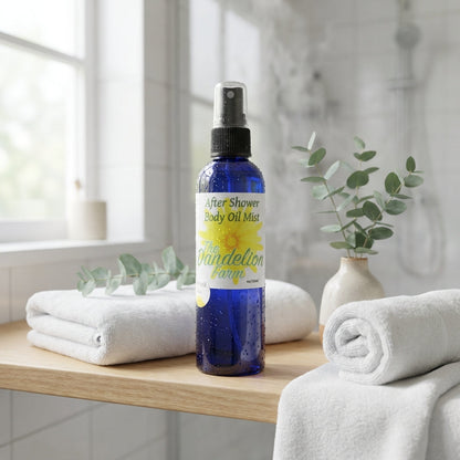 A lifestyle scene depicting the 'After Shower Body Oil Mist' on a minimalist bathroom shelf, surrounded by elements like white towels, green eucalyptus leaves, and natural light streaming through a window. The product is front and center, shot with a wide-