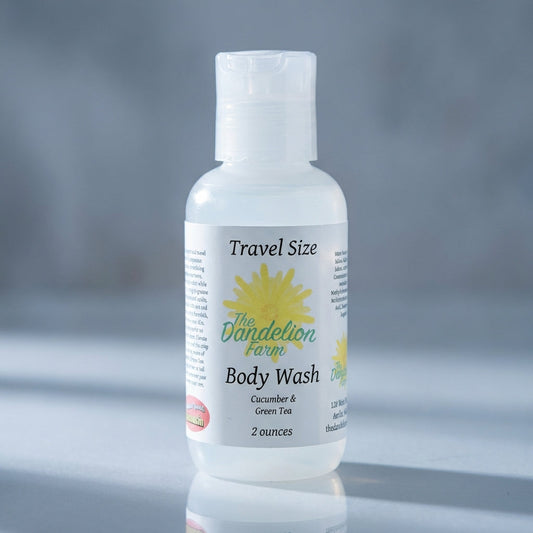 A high-resolution studio shot of a travel-size body wash bottle labeled 'Cucumber & Green Tea,' captured with a softbox lighting setup that emphasizes its sleek, transparent plastic container and crisp green label. The camera is positioned at a slight angl