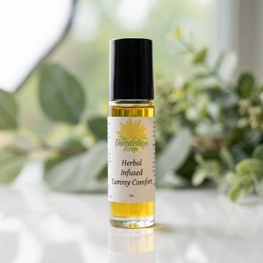 A close-up studio shot of the 'Tummy Comfort' product, a sleek, transparent glass bottle with a natural herbal label, softly illuminated by diffused daylight from a large softbox. The bottle is positioned on a pristine white surface with a subtle reflectio