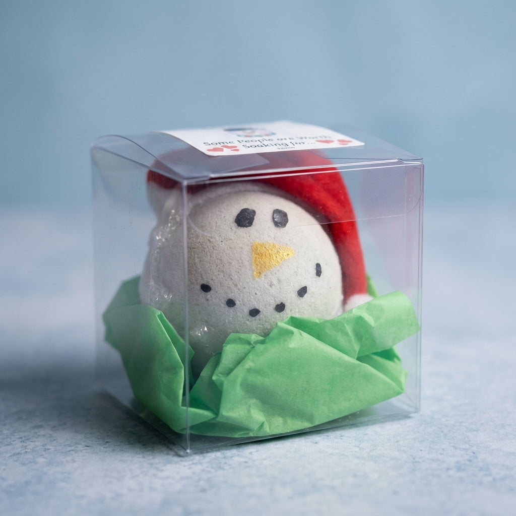 A close-up, high-resolution studio shot of the Snowman Bath Bomb, captured with a macro lens at 100mm focal length, showcasing its detailed icy snowman shape with textured, matte white surface accented by a glossy black top hat and tiny coal mimic eyes. So