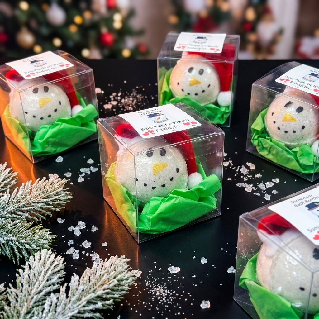 A dynamic, top-down display image of multiple Snowman Bath Bombs arranged on a sleek, black matte surface, styled to resemble a winter wonderland with icy crystals and frosted pine branches. Studio HDR lighting highlights the product’s glossy and matte fin