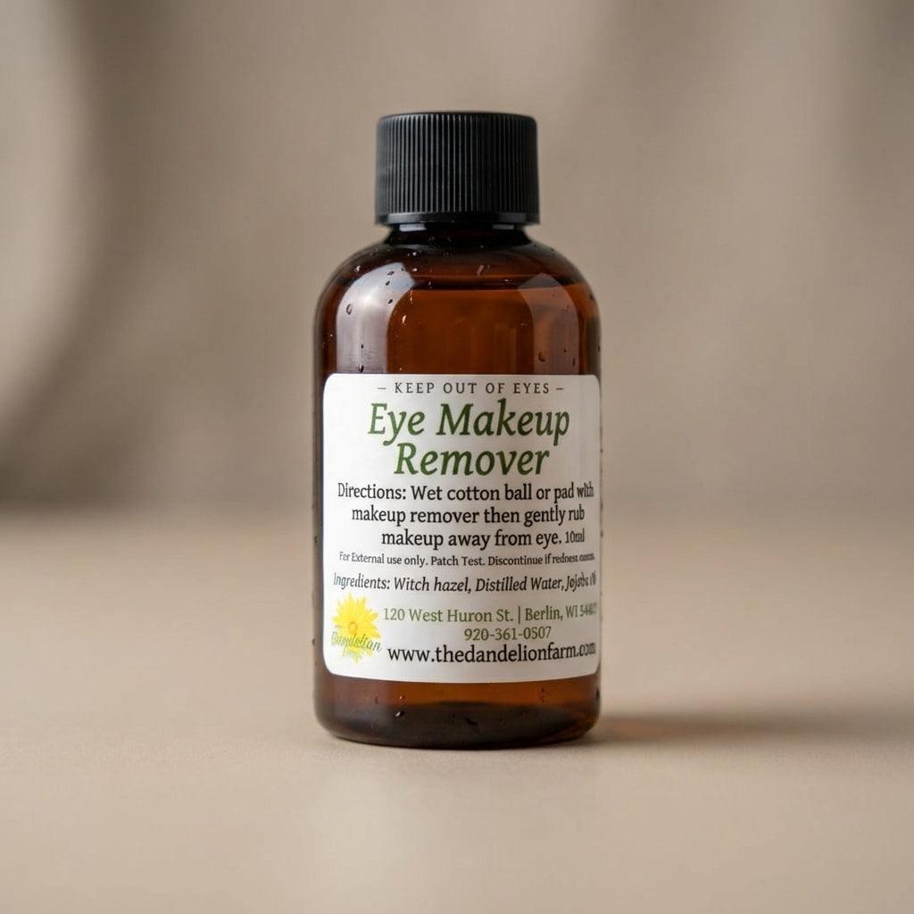 A close-up shot of an elegant, transparent glass bottle of Eye Makeup Remover, illuminated with softbox lighting that accentuates its sleek, minimalist design, set against a smooth, neutral-toned backdrop. The camera uses a macro lens at 100mm focal length
