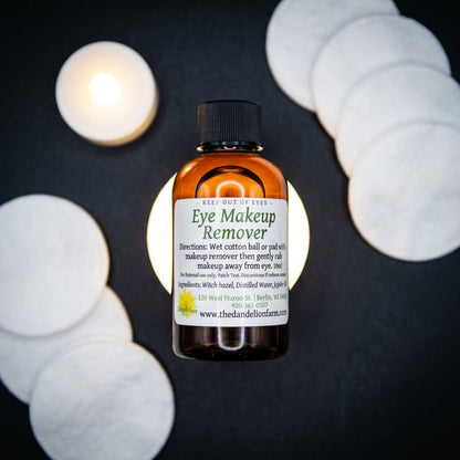 An overhead shot of the Eye Makeup Remover set against a high-contrast dark matte background to create a dramatic and sophisticated aesthetic. The product’s clear, ergonomic bottle is illuminated with a rim light that curves around its contours, emphasizin