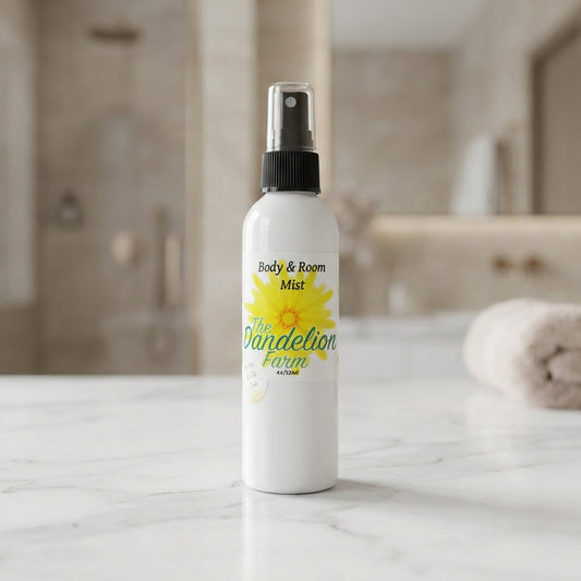 Capture a premium product shot of the 'Body & Room Mist' set against a sophisticated, softly blurred luxury bathroom background. Use a softbox lighting setup to create gentle, even illumination that highlights the reflective glass bottle with a sleek, mini