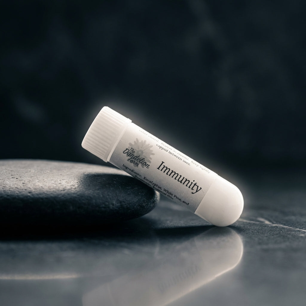 Create a dramatic, cinematic shot of the Aroma Sticks inhaler leaning against a smooth, dark stone surface, illuminated by a rim light that creates a halo effect around the product. Use a 85mm prime lens with a shallow depth of field to isolate the inhaler