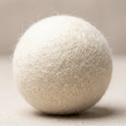 A macro shot of a single wool dryer ball, captured with an HDR studio light setup to highlight its natural wool texture, soft fibrous surface with fine fibers visible, set against a clean, minimalistic neutral background. Use a macro lens with a 100mm foca