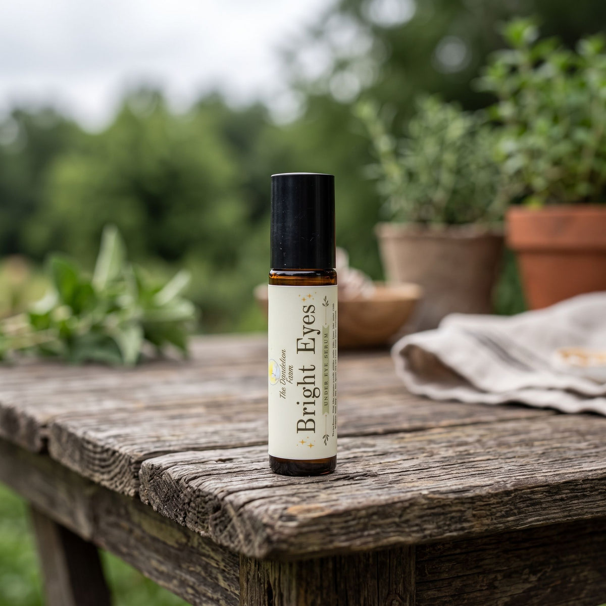 Full-body shot of petite 'Bright Eyes' serum bottle on rustic outdoor wooden table in natural daylight.