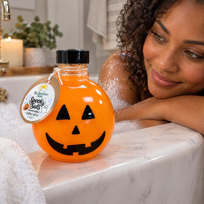 Pumpkin shaped bubble bath bottle resting on the edge of a clean white marble bathtub.