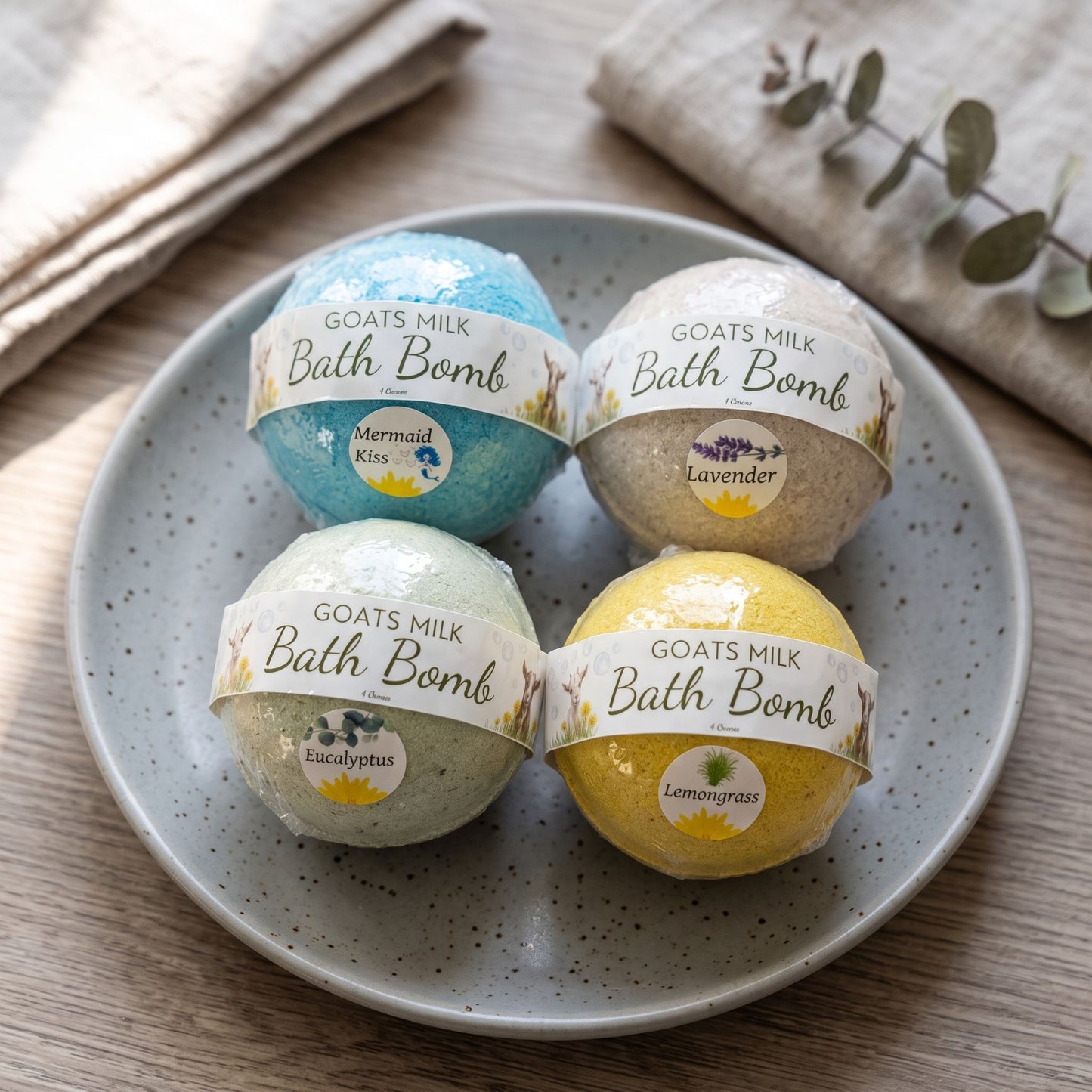 Close-up of handcrafted goat’s milk bath bombs with pastel colors on a ceramic dish, highlighting their smooth texture and handcrafted details.